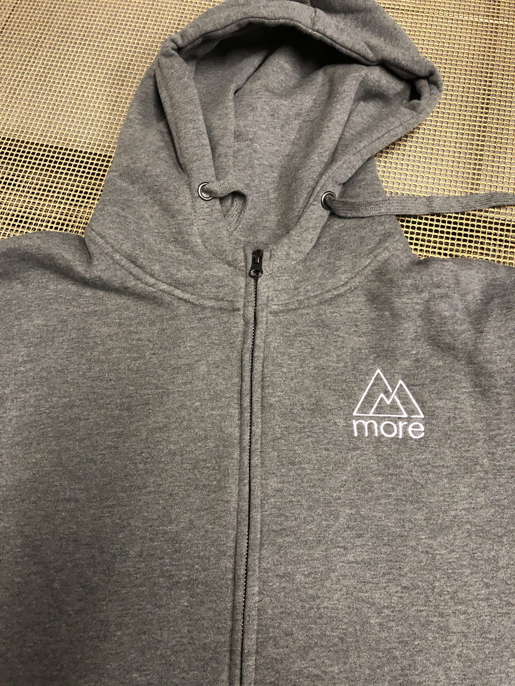 Sweat à capuche zippé gris chiné, logo brodé blanc sur la poitrine gauche